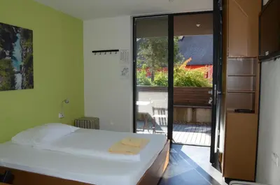 a bedroom with a bed and a large window at Hotel Sanje ob Soči ***/**** in Bovec