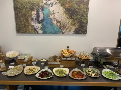 a buffet with plates of food on a table at Hotel Sanje ob Soči ***/**** in Bovec