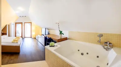a bathroom with a large bath tub in a room at Hotel Sanje ob Soči ***/**** in Bovec