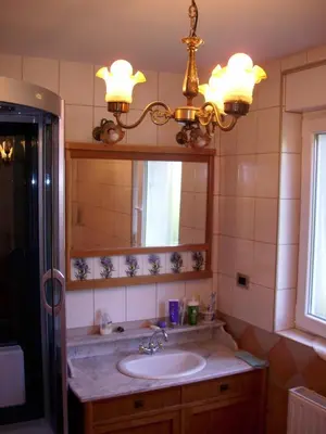 a bathroom with a sink and a mirror and a chandelier at Rooms4Young in Ljubljana