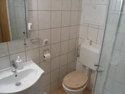 a bathroom with a toilet and a sink at Gostilna Ulčar in Ig