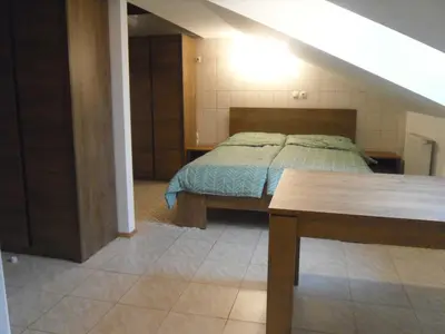 a bedroom with a bed and a table in it at Gostilna Ulčar in Ig