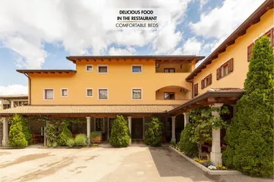 a large orange building with trees in front of it at Guest House Pod Slavnikom in Podgorje