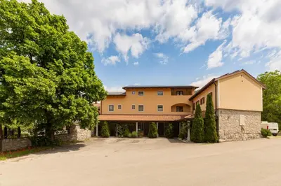 a large building with trees in front of it at Guest House Pod Slavnikom in Podgorje