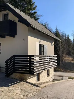 a house with a wooden porch on the side of it at Holiday house Nune in Zreče