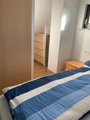 a bedroom with a blue comforter on a bed at Holiday house Nune in Zreče