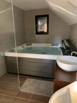 a bathroom with a tub with a sink and a toilet at Holiday house Nune in Zreče