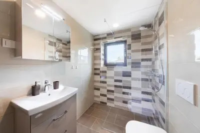 a white bathroom with a sink and a shower at Lake Bled Apartment Marjetka in Bled