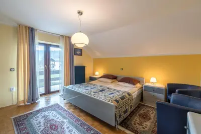 a bedroom with a bed and a large window at Lake Bled Apartment Marjetka in Bled
