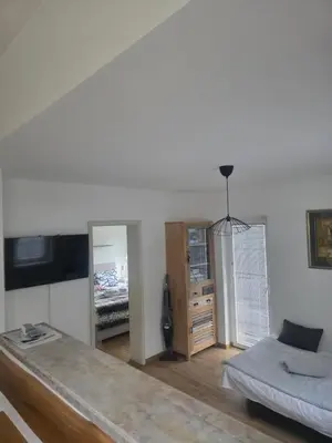 a white room with a bed and a mirror at Apartment Amy in Podčetrtek