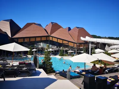 a pool with chairs and umbrellas at a resort at Apartment Amy in Podčetrtek
