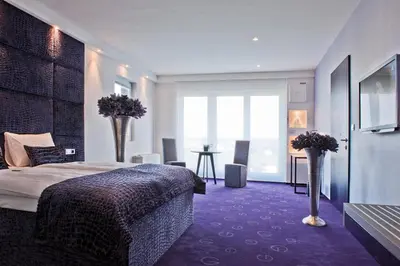 a hotel room with a bed and flowers in it at G Design Hotel in Ljubljana
