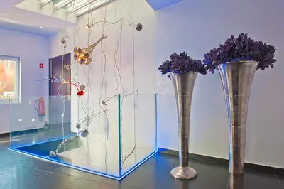 two vases with purple flowers in a room at G Design Hotel in Ljubljana