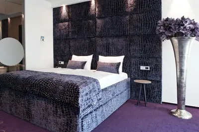 a bedroom with a bed and a vase with flowers at G Design Hotel in Ljubljana