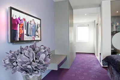 a living room with a tv and a plant at G Design Hotel in Ljubljana