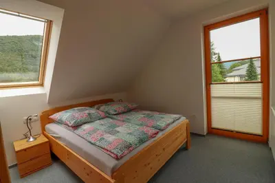 a bedroom with a bed with two pillows on it at Apartments & Rooms Pr' Skalovc in Bohinj