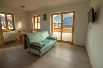 a living room with a couch and a table at Apartments & Rooms Pr' Skalovc in Bohinj