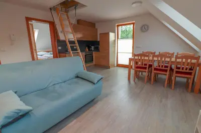 a living room with a blue couch and a dining room at Apartments & Rooms Pr' Skalovc in Bohinj