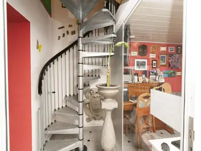 a spiral staircase in a room with a plant at Hostel 24 in Ljubljana