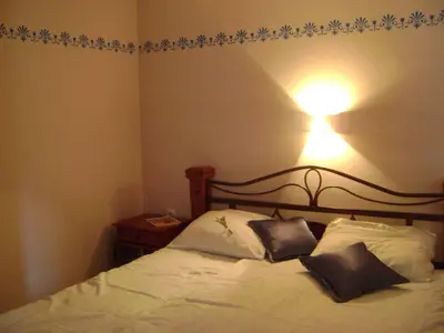 a bedroom with a bed with a light on the wall at Merkež Guest House in Bizeljsko