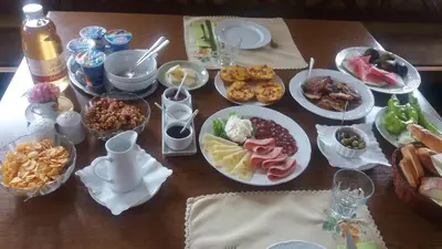 a wooden table with plates of food on it at Merkež Guest House in Bizeljsko