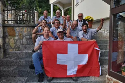 a group of men standing on steps holding a flag at Grobelnik Tourist Farm in Sevnica
