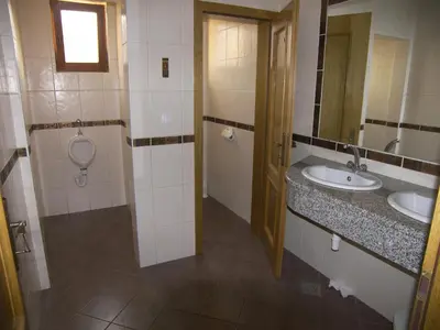 a bathroom with two sinks and a toilet and a mirror at Grobelnik Tourist Farm in Sevnica