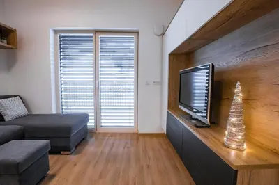 a living room with a television and a couch at Vila Mojca Apartma Eva-Neža, Kranjska Gora (center) in Kranjska Gora