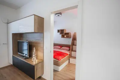 a small bedroom with a bed and a television at Vila Mojca Apartma Eva-Neža, Kranjska Gora (center) in Kranjska Gora