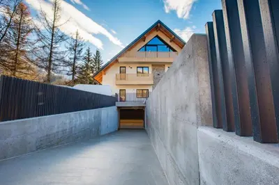 a house with a fence in front of it at Vila Mojca Apartma Eva-Neža, Kranjska Gora (center) in Kranjska Gora