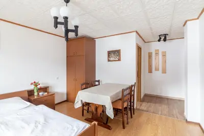 a bedroom with a table and chairs and a bed at Apartment house Jager in Bohinj