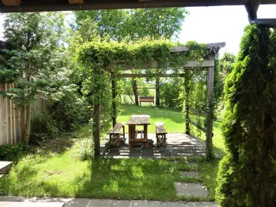 a pergola with a table and chairs in a yard at Pension Na Meji in Pivka