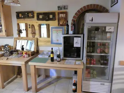 a room with a desk and a refrigerator with bottles of wine at Pension Na Meji in Pivka