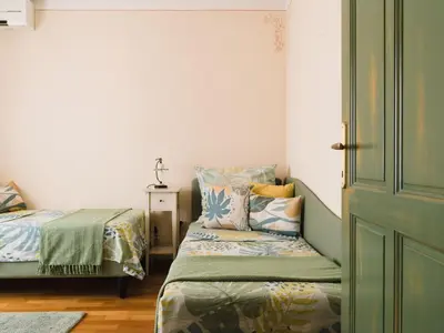 a bedroom with two beds and a door at Špacapanova hiša in Komen