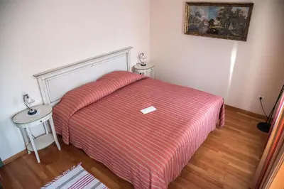 a bedroom with a bed with a red striped blanket at Špacapanova hiša in Komen