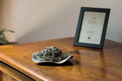 a bowl of debris on a wooden table with a picture at Špacapanova hiša in Komen