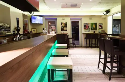 a bar with a counter and stools in a restaurant at Hostel Plus Caffe in Petrovče