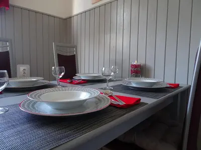 a table with plates and wine glasses and a candle at Apartma Sebastjan Dobova near Terme Paradiso in Dobova