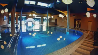 a large swimming pool with blue water in a building at Apartma Sebastjan Dobova near Terme Paradiso in Dobova