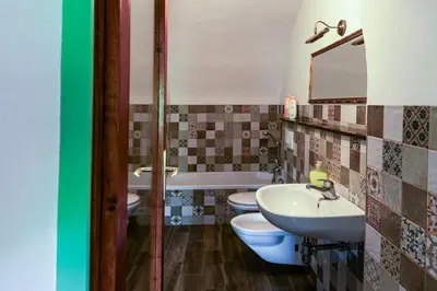a bathroom with two toilets and a sink and a tub at House, Garden and a Green Cat in Bled