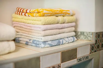 a stack of towels on a shelf in a bathroom at House, Garden and a Green Cat in Bled