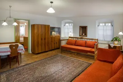 a living room with a couch and a table at House, Garden and a Green Cat in Bled