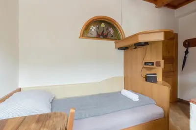 a small bedroom with a bed and a table at Cozy, Bright and Affordable Single Studio - Free Parking in Ljubljana