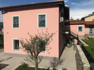 a pink house with a tree in front of it at Vila Burbonka in Nova Gorica