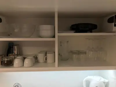 a kitchen cabinet filled with lots of dishes and glassware at Vila Burbonka in Nova Gorica