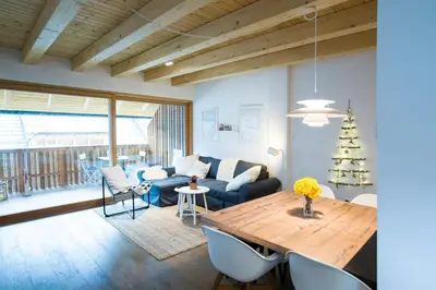 a living room with a blue couch and a table at Apartments Maison in Kranjska Gora