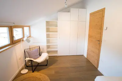 a small room with a chair and a closet at Apartments Maison in Kranjska Gora