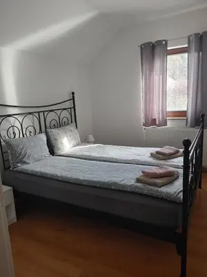 a bed with a black frame and a window at Apartma Katja in Mojstrana