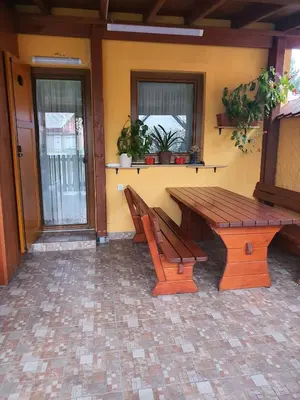 a wooden bench and a table on a patio at Terme Čatež Apartma Nine in Čatež ob Savi