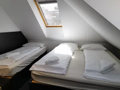 two beds in a small room with a window at Cha Cha Rooms in Ljubljana